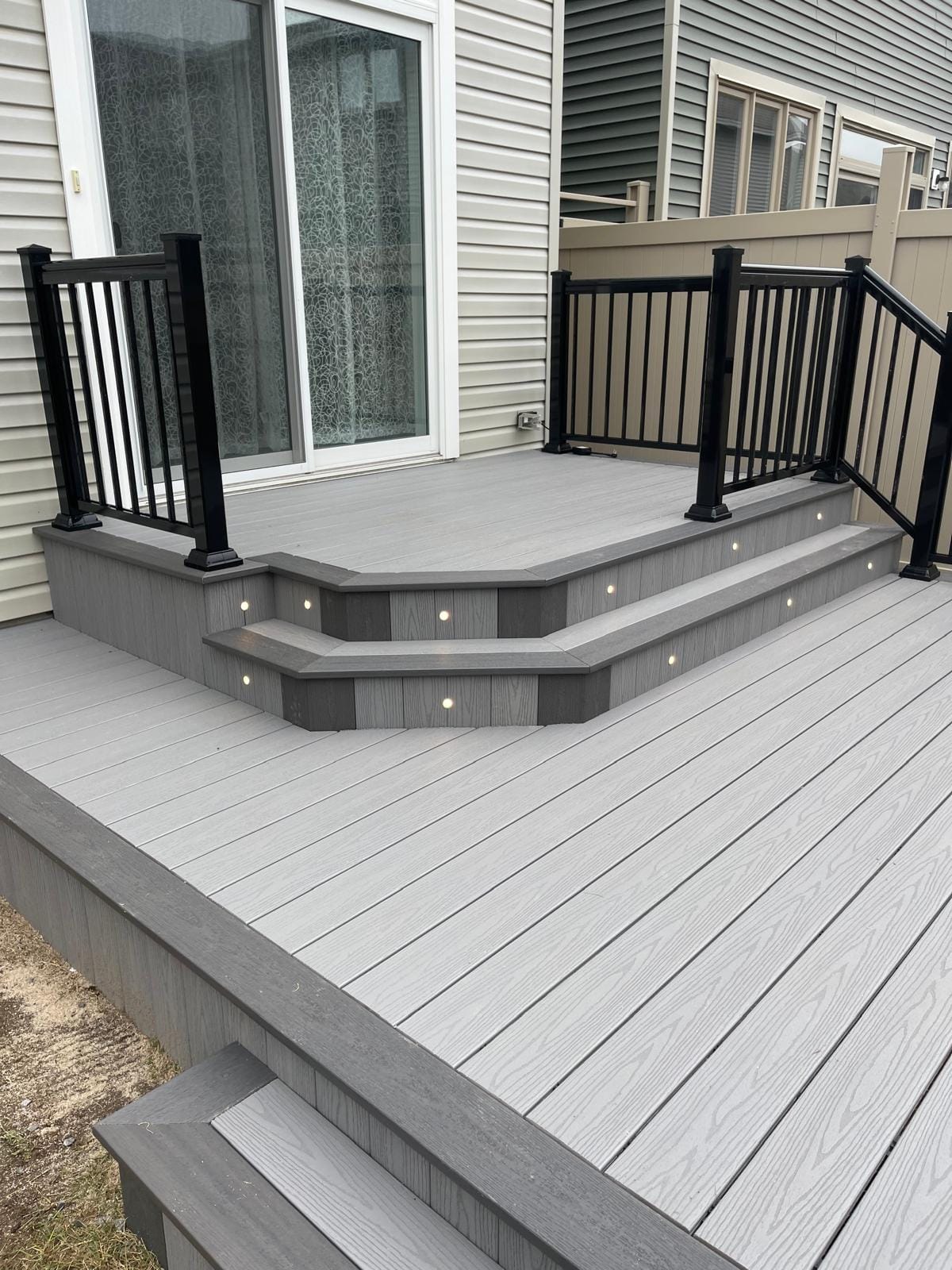 Composite deck with built-in step lights and black railings