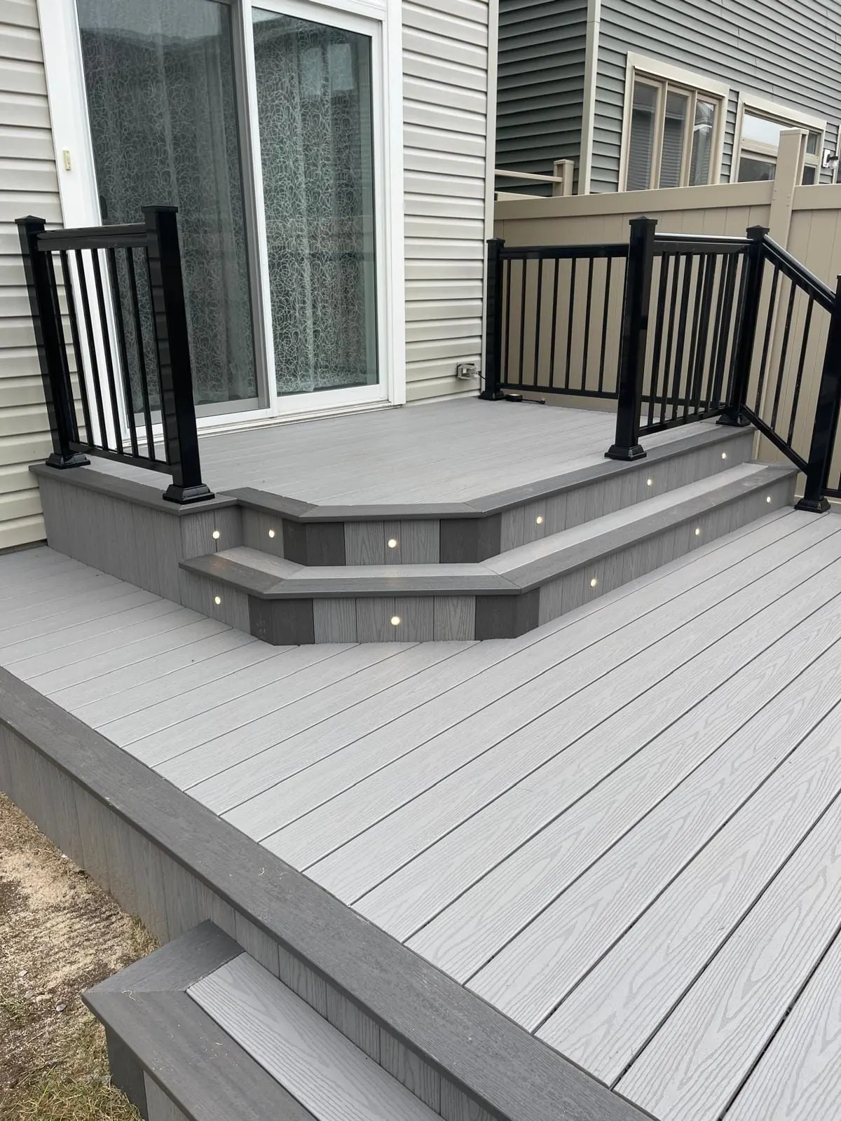 Composite deck with built-in step lights and black railings