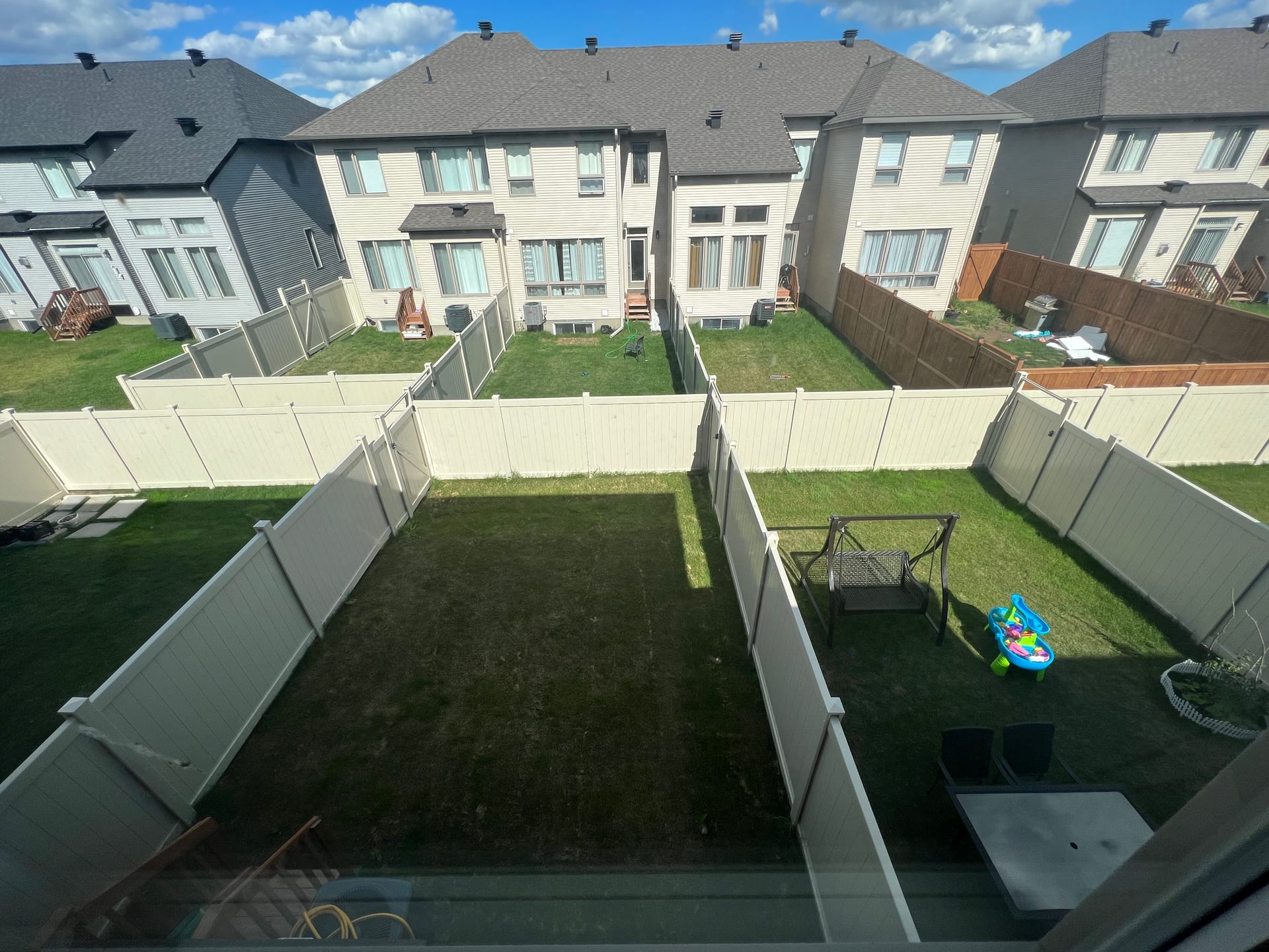 White PVC fence enclosing full backyard, aerial view