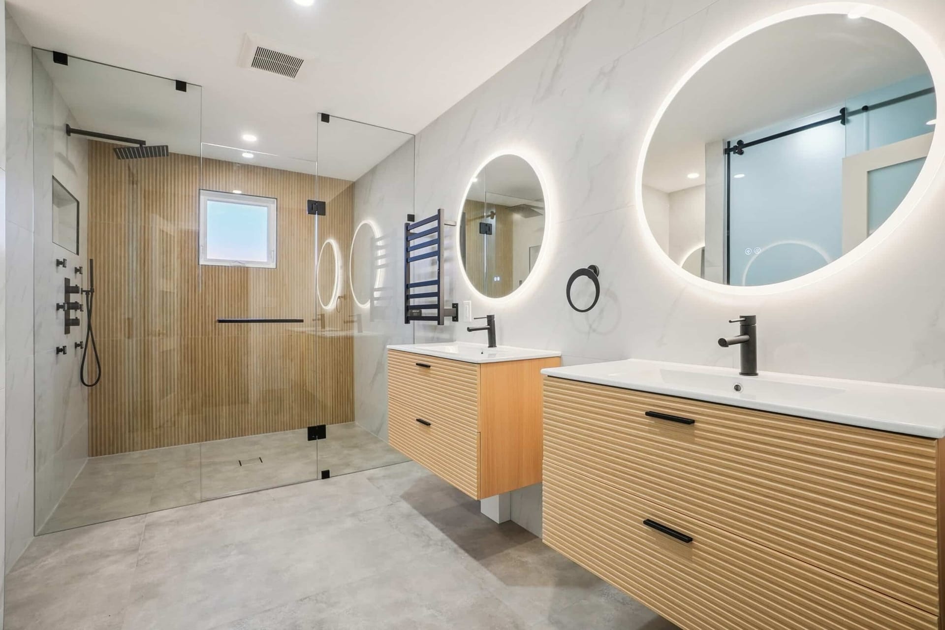 Luxury marble bathroom renovation with freestanding tub and glass shower