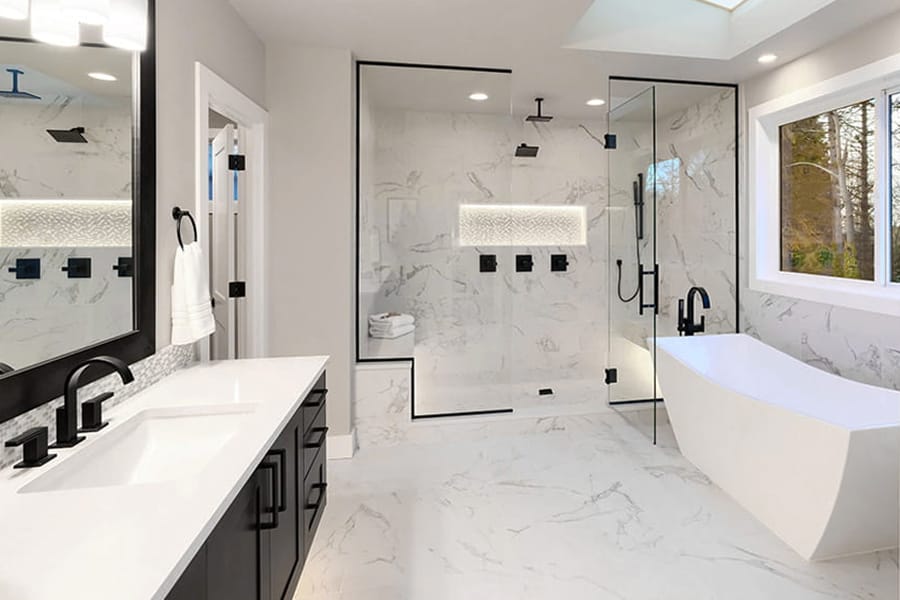 Classic marble bathroom renovation with glass shower and dark vanity